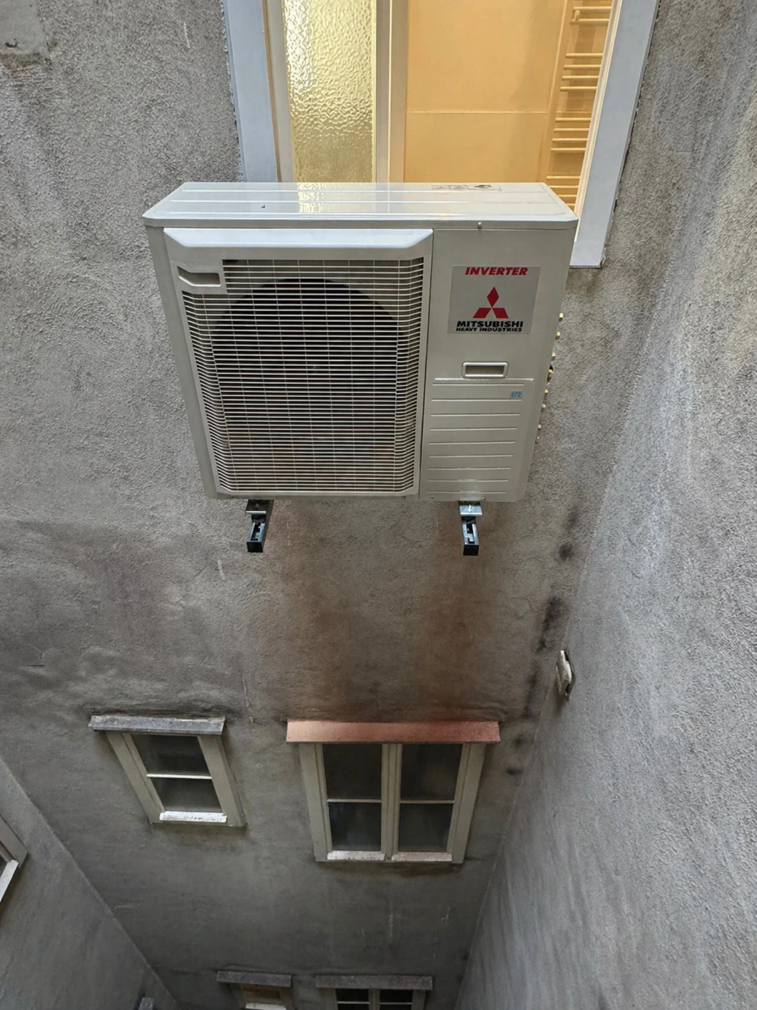 Zufriedener Kunde mit Klimaanlage Außengerät im Innenhof von Klimadealer