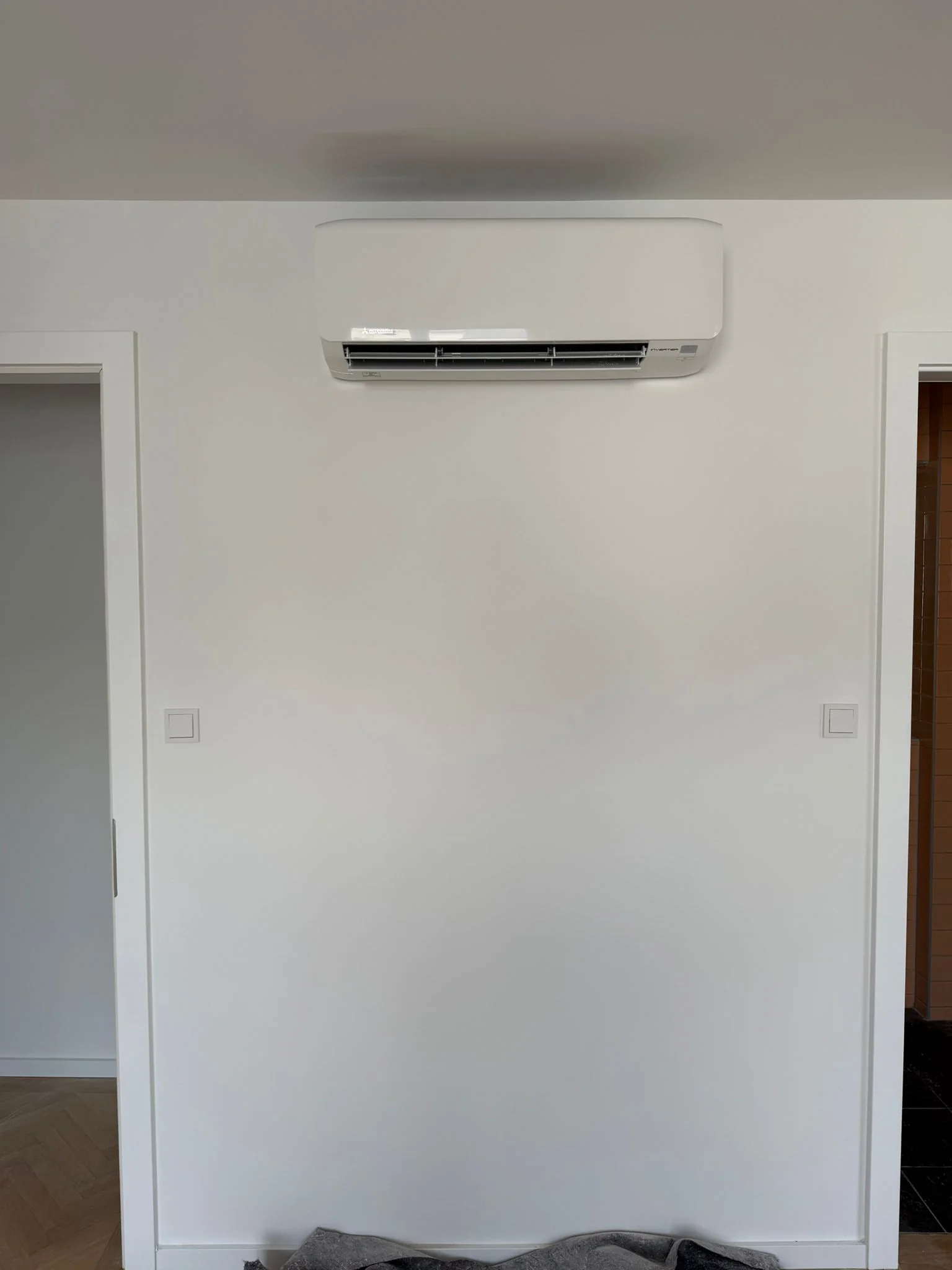Zufriedener Kunde mit Klimaanlage neben Badezimmer von Klimadealer