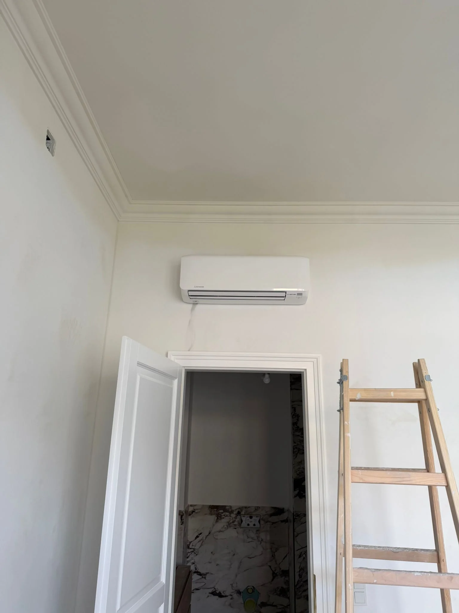 Zufriedener Kunde mit Klimaanlage im Wohnzimmer mit hohen Decken von Klimadealer