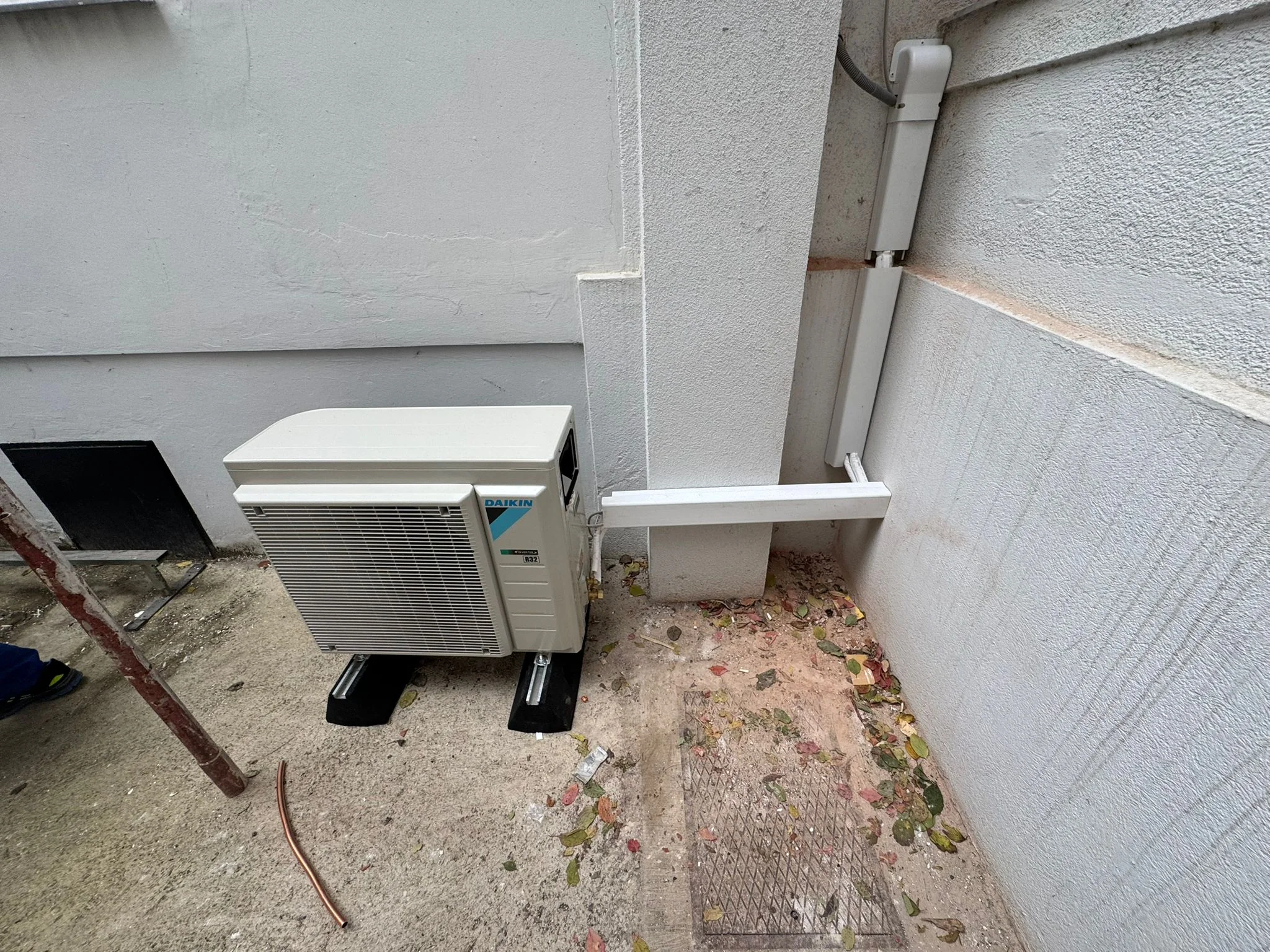 Zufriedener Kunde mit Klimaanlage Daikin Außengerät im Innenhof von Klimadealer