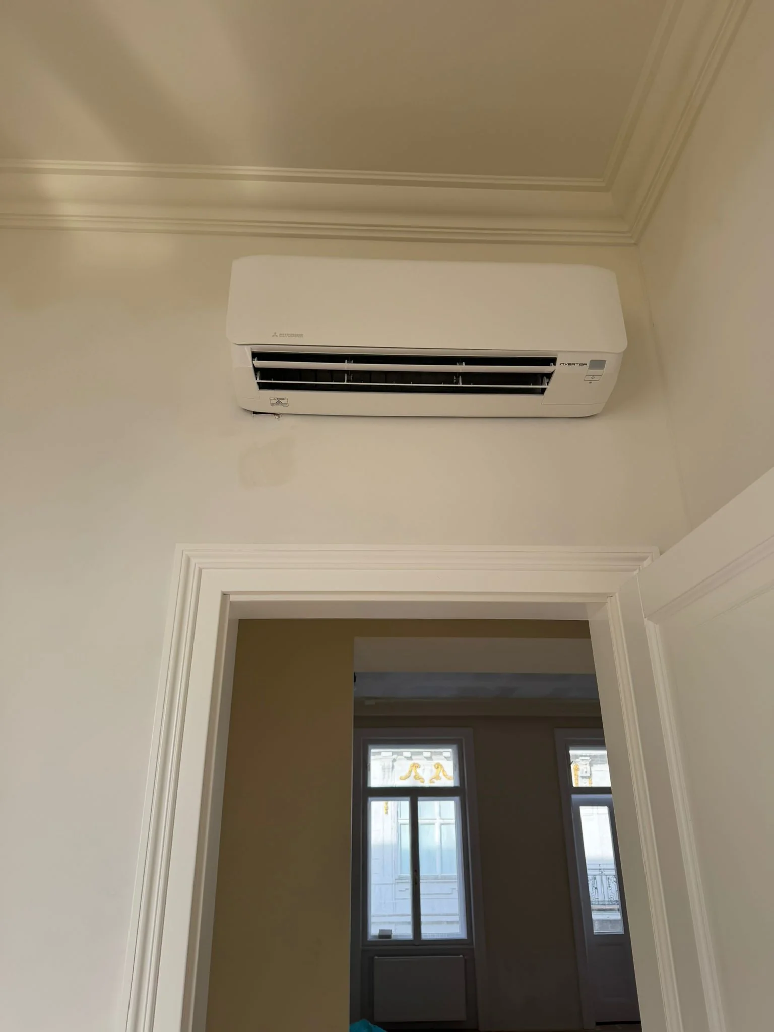 Zufriedener Kunde mit Klimaanlage am Gang in einer Altbauwohnung von Klimadealer
