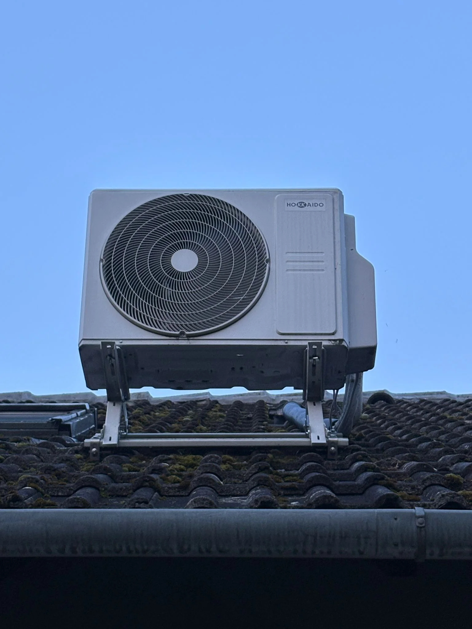 Zufriedener Kunde mit Klimaanlage Außengerät von Hokkaido am Dach von Klimadealer